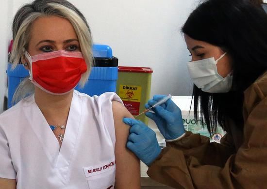 A medical worker receives a dose of China's Sinovac COVID-19 vaccine at the Sabiha Uzun Maternal Child Health Center in Ankara, Turkey on Jan. 15, 2021. (Photo by Mustafa Kaya/Xinhua)